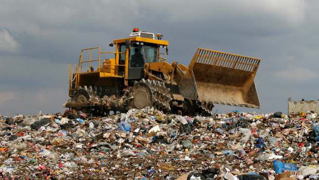 Bulldozer compactant des déchets dans une décharge à ciel ouvert en Suède