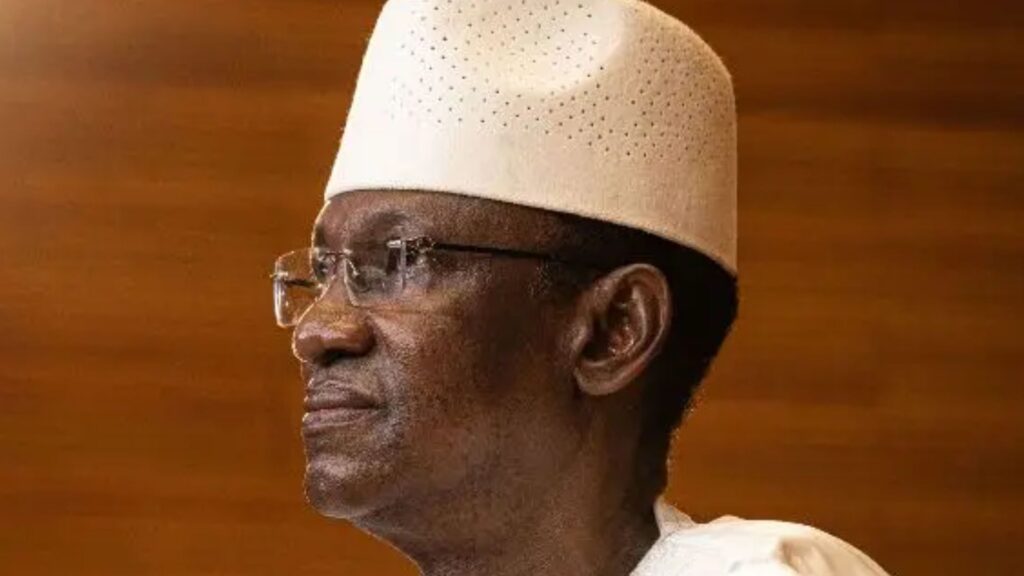 Portrait de Choguel Maïga en boubou blanc et chapeau traditionnel malien.