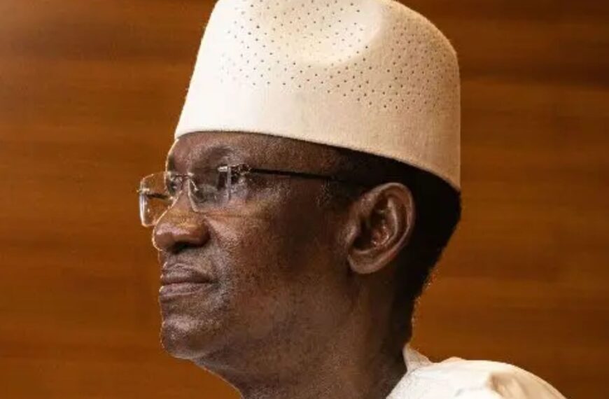 Portrait de Choguel Maïga en boubou blanc et chapeau traditionnel malien.