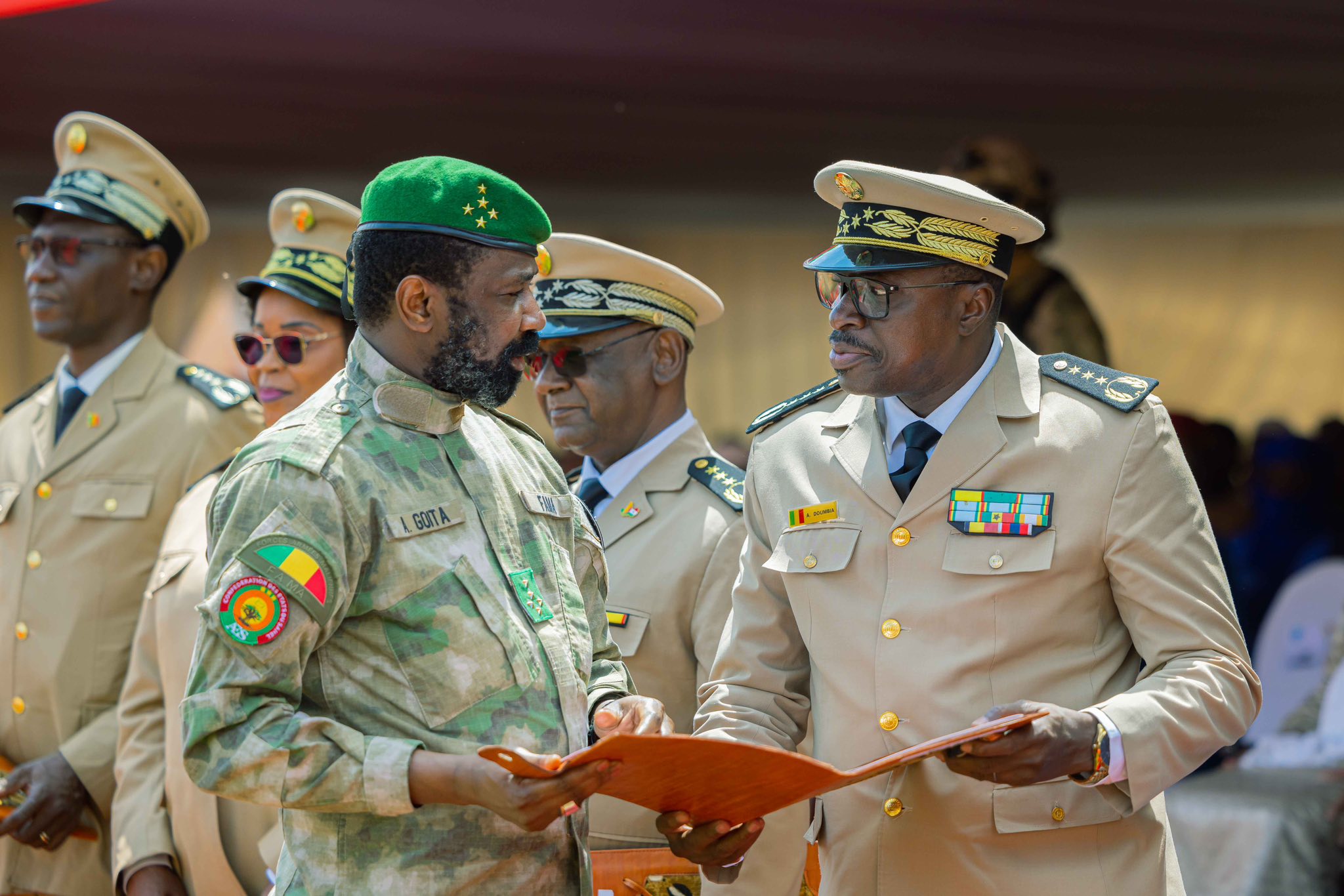 Officiers maliens en uniforme discutant lors d’une cérémonie officielle.