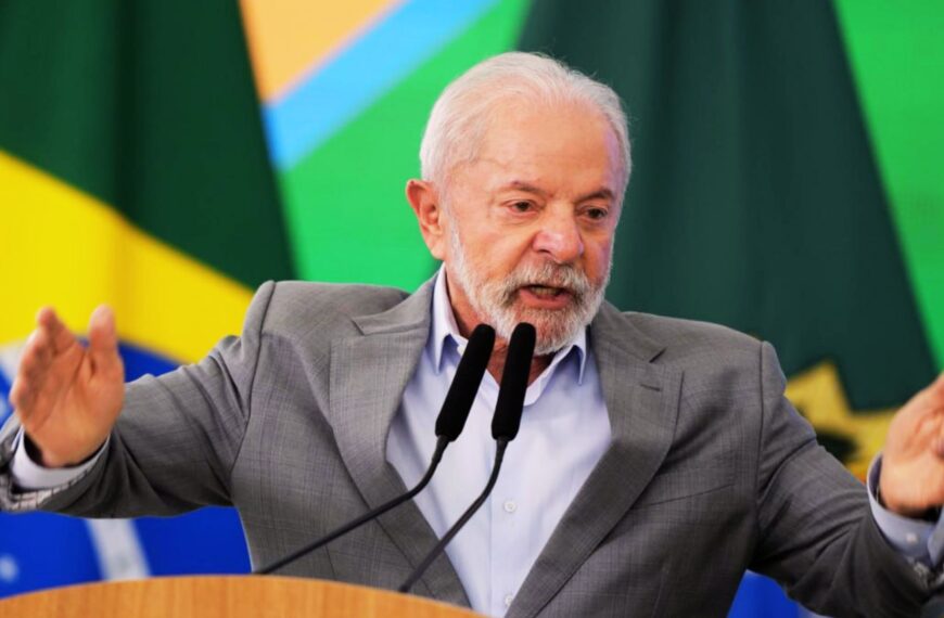 Lula da Silva prononce un discours énergique au pupitre, devant les drapeaux brésiliens.