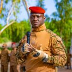 Le capitaine Ibrahim Traoré, président de la transition du Burkina Faso, en tenue militaire, tenant un micro, s’adressant à des soldats alignés en arrière-plan.