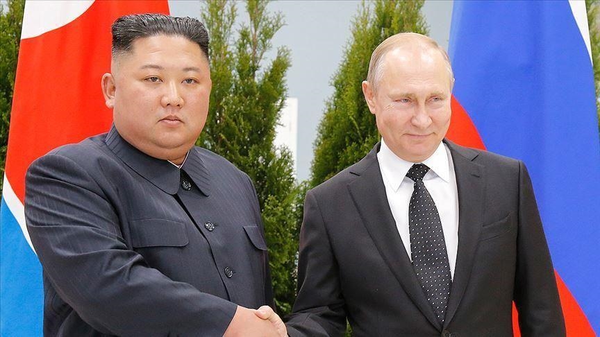 Kim Jong-un et Vladimir Poutine se serrant la main lors d’une rencontre officielle, devant les drapeaux nord-coréen et russe.
