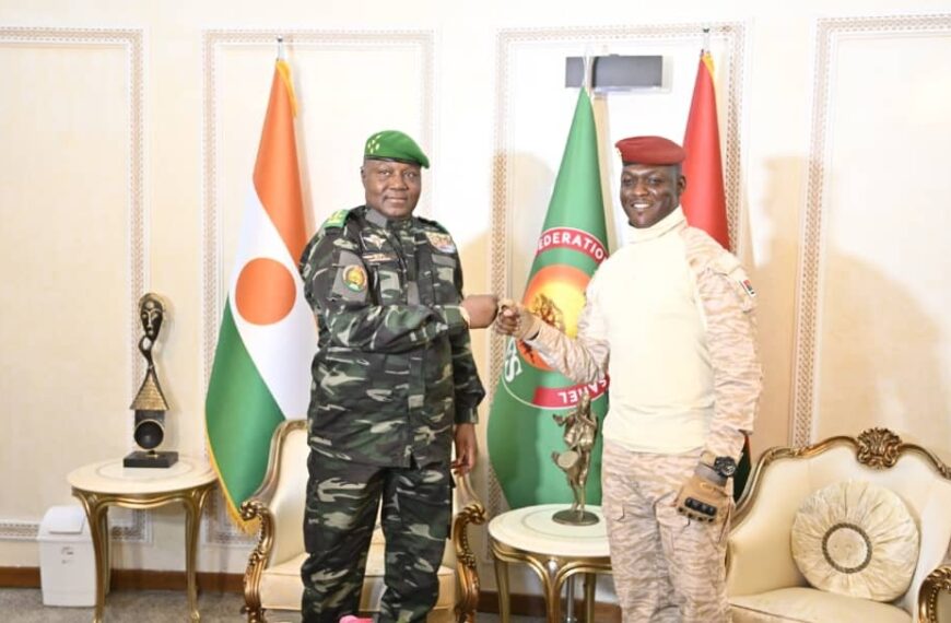 Abdourahamane Tiani et Ibrahim Traoré se serrent la main devant les drapeaux du Niger, du Burkina Faso et de l’AES.