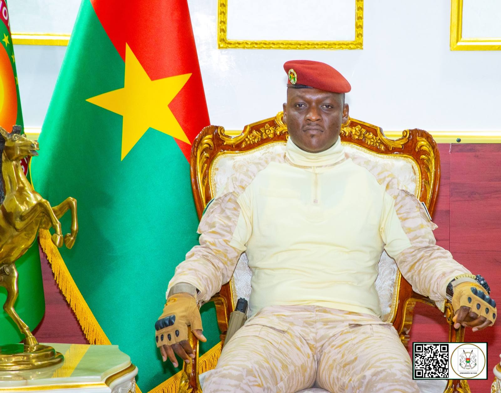 Capitaine Ibrahim Traoré assis sur un fauteuil officiel devant le drapeau du Burkina Faso