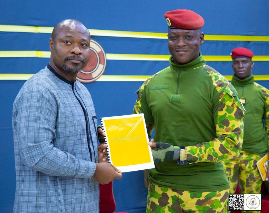 Guy Marius Sagna remet un document officiel au président burkinabè à Ouagadougou.