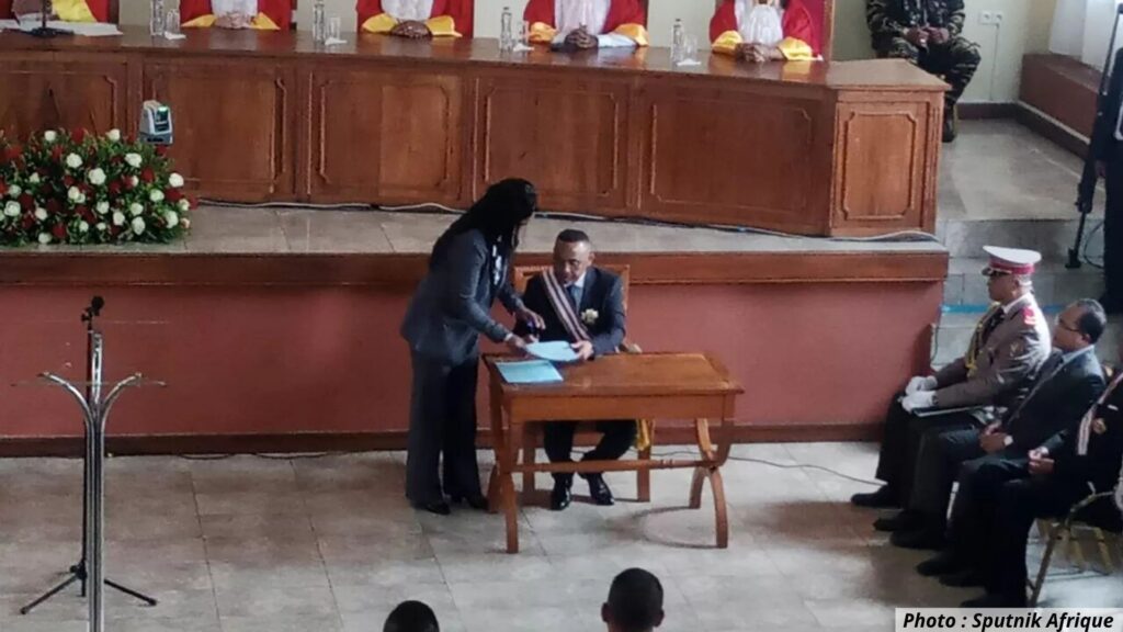 Le colonel Michaël Randrianirina signe un document officiel lors de sa cérémonie d’investiture à Antananarivo, en présence de magistrats et d’officiers de l’armée malgache.