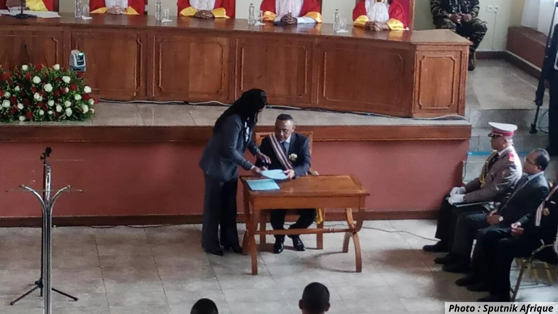 Le colonel Michaël Randrianirina signe un document officiel lors de sa cérémonie d’investiture à Antananarivo, en présence de magistrats et d’officiers de l’armée malgache.