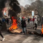 Manifestants à Madagascar marchant dans les rues aux côtés de pneus en feu et de barricades, lors d’un mouvement de protestation contre le gouvernement.