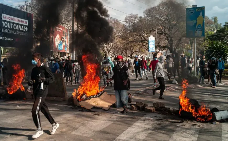 Manifestants à Madagascar marchant dans les rues aux côtés de pneus en feu et de barricades, lors d’un mouvement de protestation contre le gouvernement.