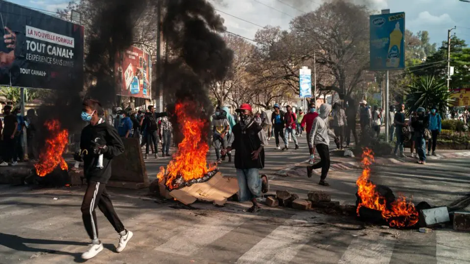 Manifestants à Madagascar marchant dans les rues aux côtés de pneus en feu et de barricades, lors d’un mouvement de protestation contre le gouvernement.