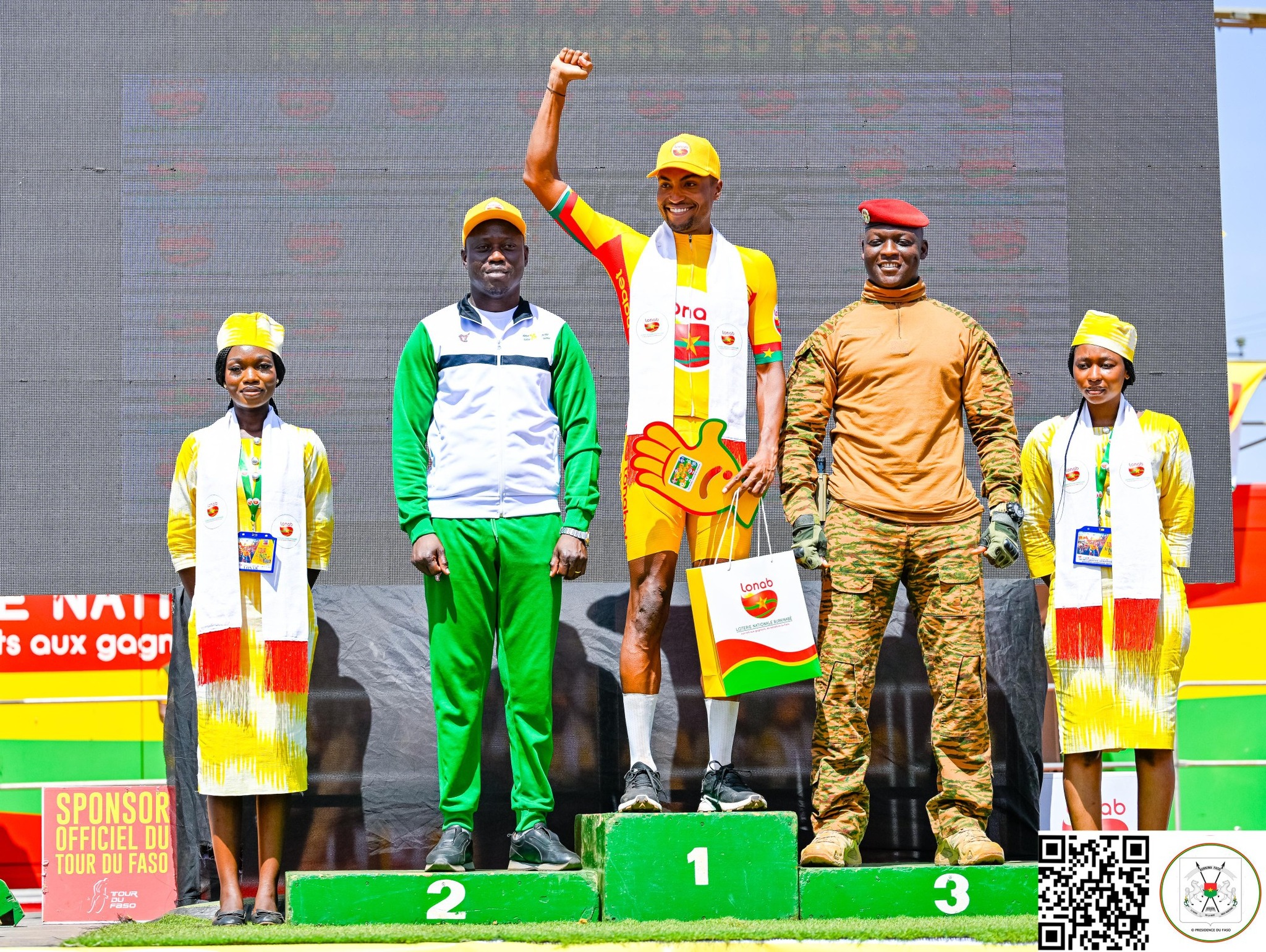 Ibrahim Traoré remet une prime à un cycliste lors de la cérémonie finale du Tour du Faso.