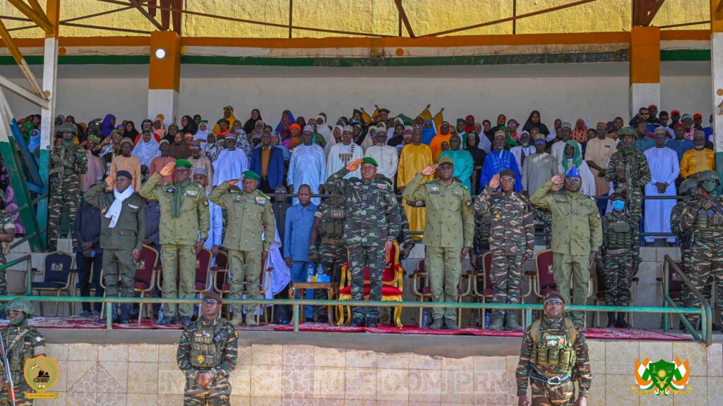 Le Général d’Armée Abdourahamane Tiani, entouré de responsables civils et militaires, debout sur une tribune officielle devant une foule rassemblée à Dosso.