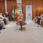 Réunion officielle entre une délégation militaire russe et des responsables militaires au Mali, assis en face à face dans une salle de conférence.
