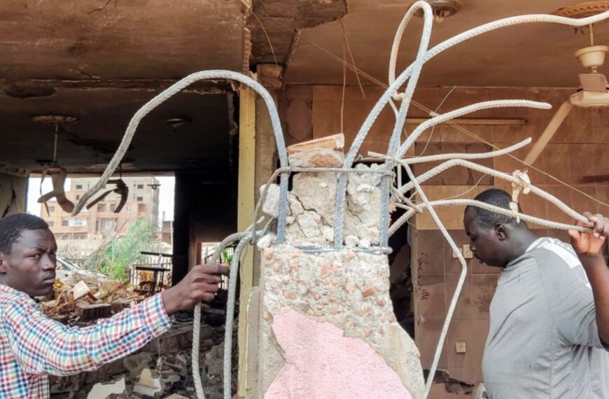 Personnes inspectant les décombres d’une maison détruite après un tir d’artillerie à Khartoum, au Soudan.