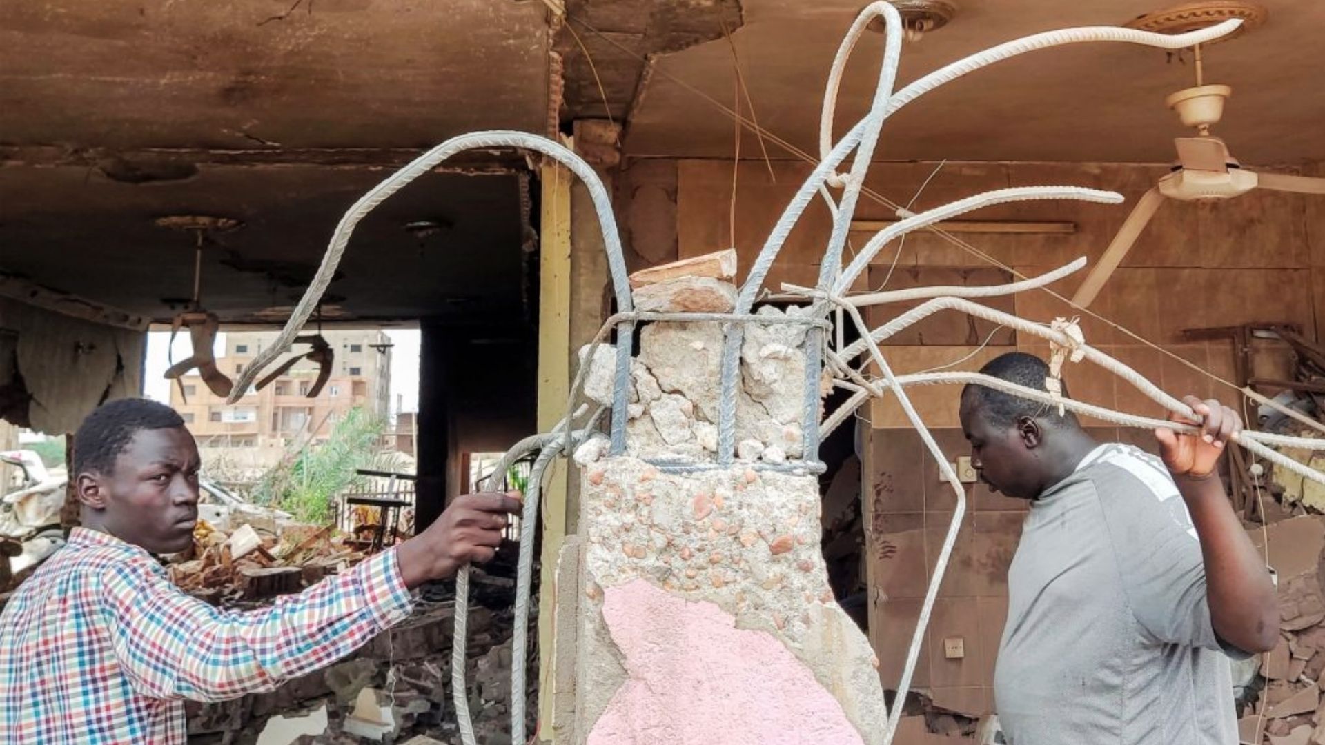 Personnes inspectant les décombres d’une maison détruite après un tir d’artillerie à Khartoum, au Soudan.